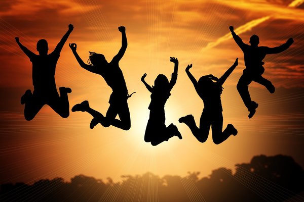fünf springenede Menschen in die Luft bei Sonnenuntergang