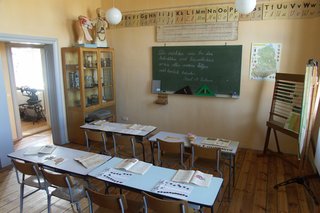 ein Klassenzimmer mit Tafel, Stühlen und Tischen